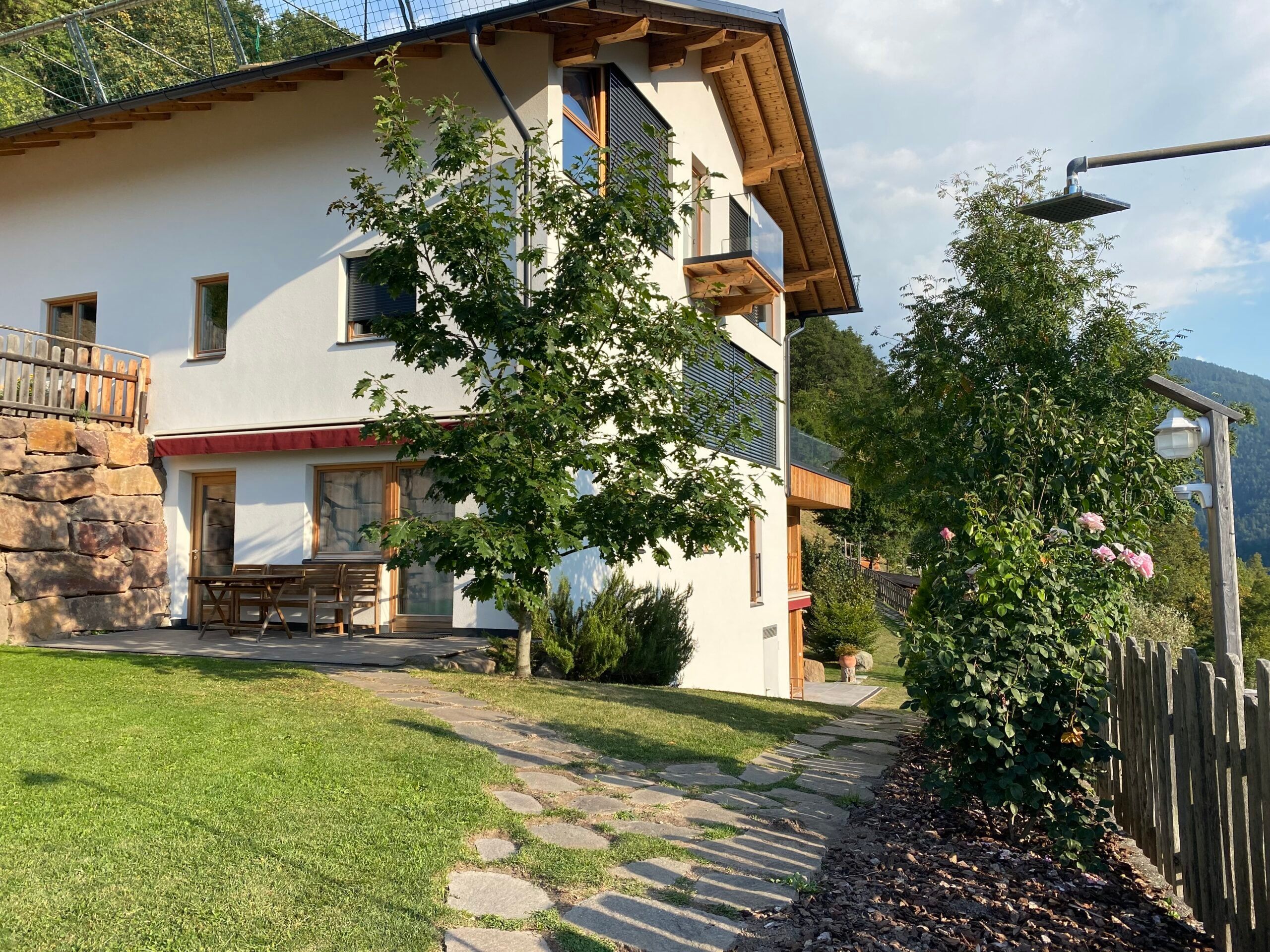 Farmhouse of the Brentwaldhof with wooden balcony, garden and stone path